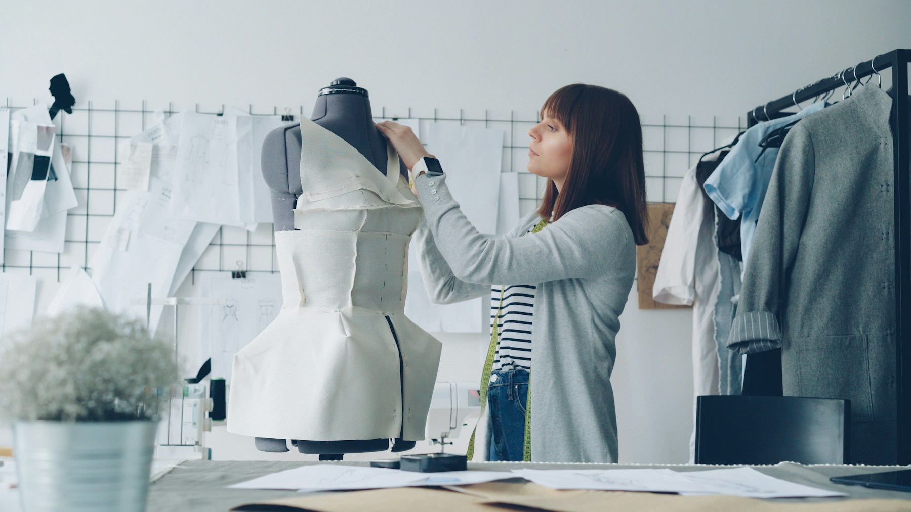 Designer construindo uma peça de moda em um manequim no ateliê